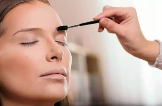 A woman applying eyebrow makeup