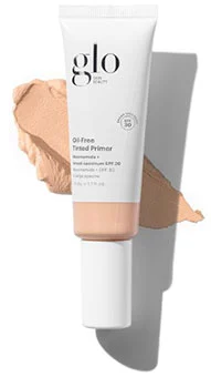 A tube of Glo Skin Beauty Oil Free Tinted Primer next to a swatch of the tinted product highlighting its smooth texture and natural finish.