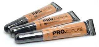 Three tubes of LA Girl Pro Conceal High Definition Concealer arranged diagonally on a white surface.