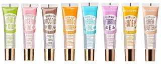 A row of Ruby Kisses Broadway Vita-Lip Clear Lip Gloss tubes in various flavors, including mint oil, coconut oil, mango oil, vitamin E, honey, and shea butter, showcasing a colorful selection perfect for enhancing lip care.