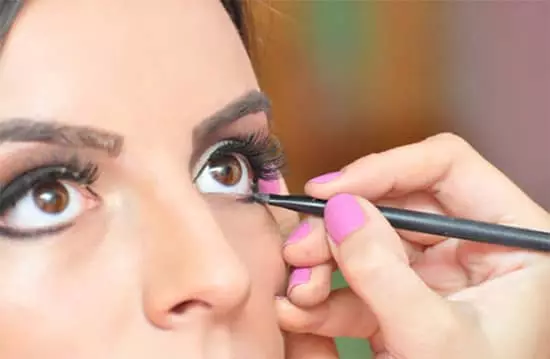 A woman applying eyeliner