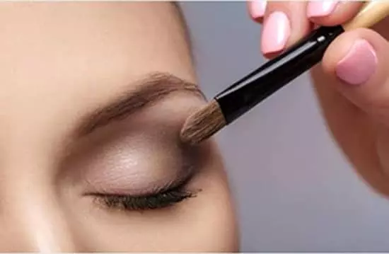 A young lady applying eyeshadow